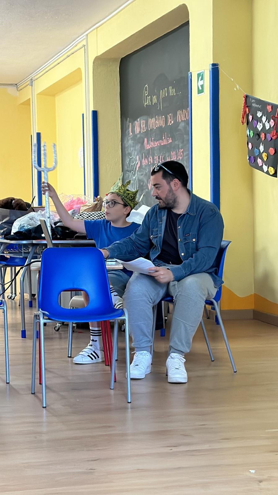 Un bambino prova una scena insieme a un educatore teatrale
